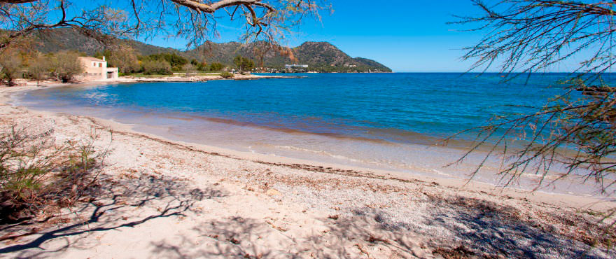 Playa de arena blanca y agua cristalina delante de apartamentos de Taylor Wimpey