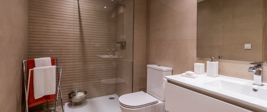 Полностью оборудованная современная ванная комната с душевыми перегородками в жилом комплексе «Sun Valley».