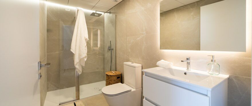 Modernes, voll ausgestattetes Bad mit installierten Duschwänden, in der Wohnanlage Iconic