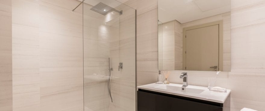 Modernes, voll ausgestattetes Bad mit installierter Duschtrennwand eines Apartments in der Wohnanlage Harmony