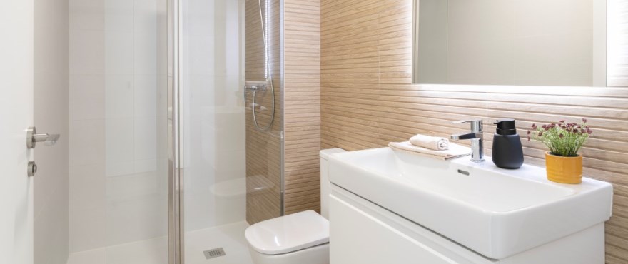 Modernes, voll ausgestattetes Bad mit installierten Duschwänden, in der Wohnanlage Amara