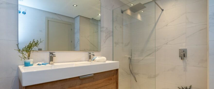 Baño moderno y completo en Solana Village, con mamparas instaladas.