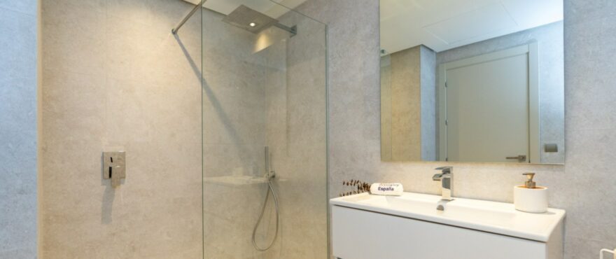Modernes, voll ausgestattetes Bad mit installierter Duschtrennwand eines Apartments in der Wohnanlage Solana Village.