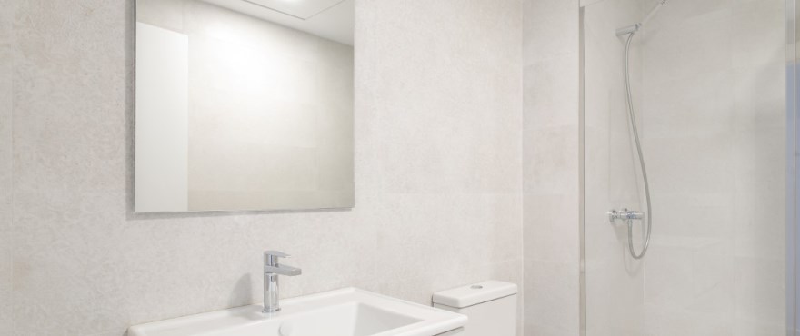 Modernes, voll ausgestattetes Bad mit festinstallierten Duschwänden in der Wohnanlage Breeze