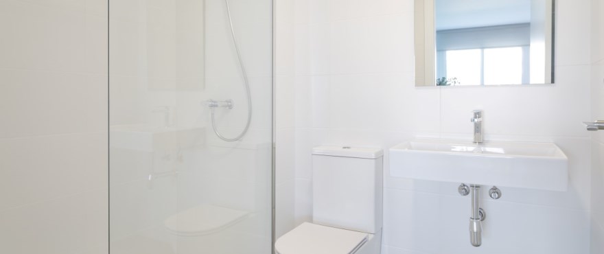 Modernes, voll ausgestattetes Bad mit festinstallierten Duschwänden in der Wohnanlage Breeze